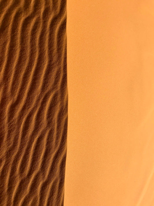 a desert scene with a sand dune in the background