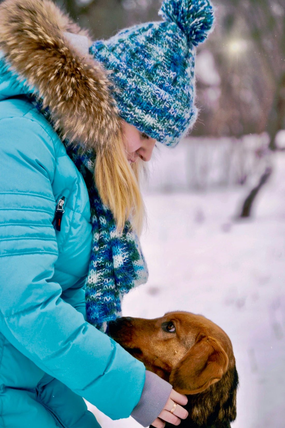 a woman is petting a dog in the snow